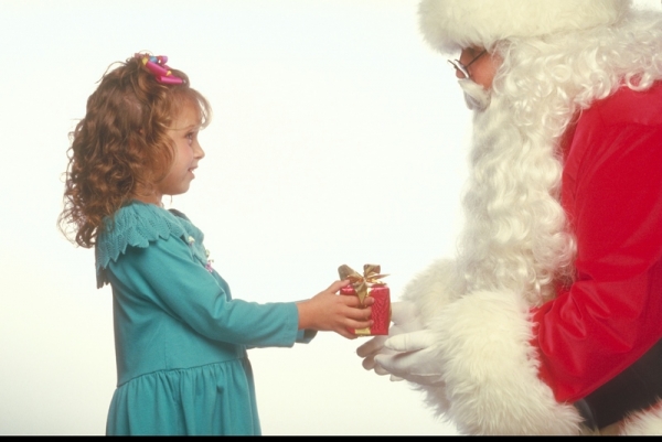 Санта Клаус вручает подарок девочке - фото 