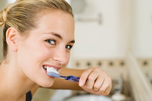 Женщина чистит зубы 