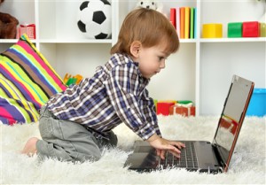 Ребенок смотрит передачу по ноутбуку - фото