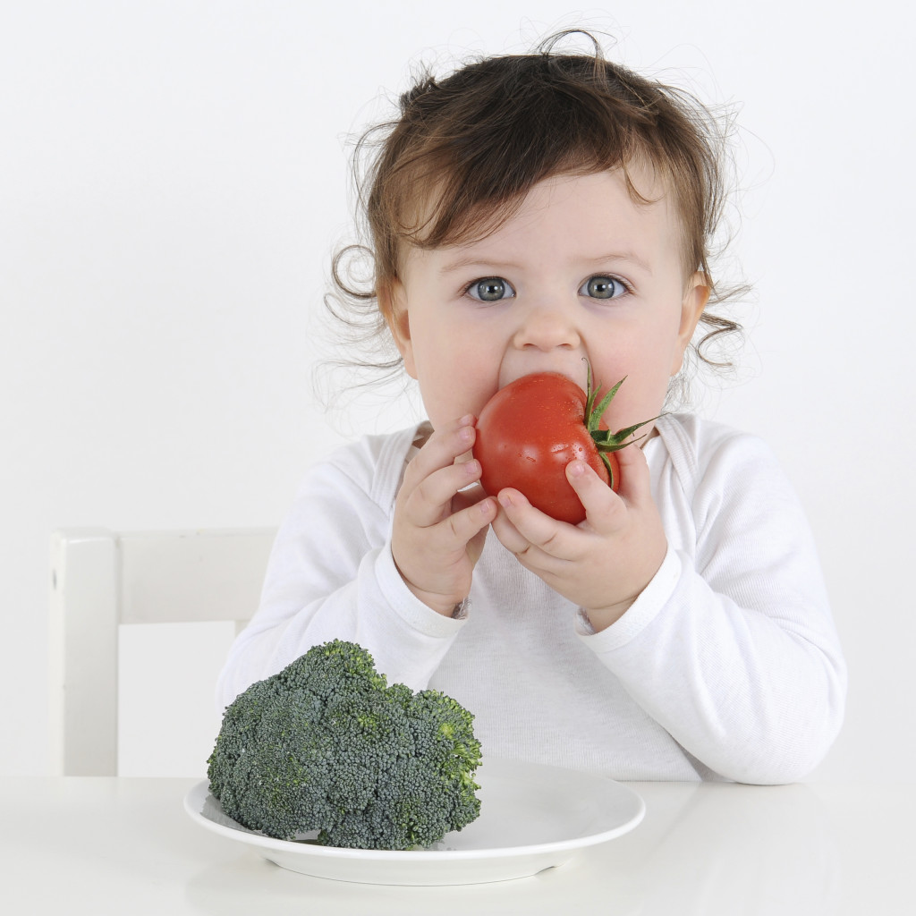 Ребенок ест овощи - фото