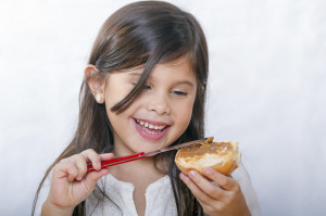 Дівчинка їсть тістечко (фото: Thinkstockphotos/fotobank.ua)