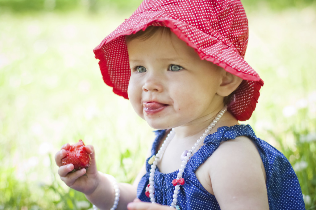 Девочка ест клубнику - фото