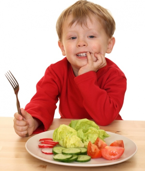 Мальчик ест овощи - фото