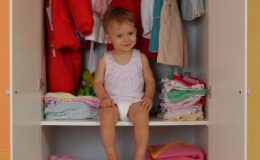 Маленький ребенок сидит в шкафу - фото
