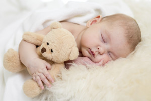 Ребенок спит с игрушкой  - фото