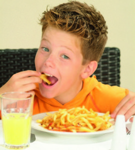 Мальчик ест картофель фри (фото: Burda Media)