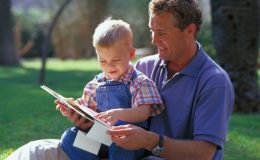 Папа с маленьким сыном читают книгу - фото