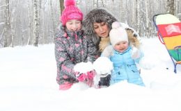 Мама с детьми на зимней прогулке - фото