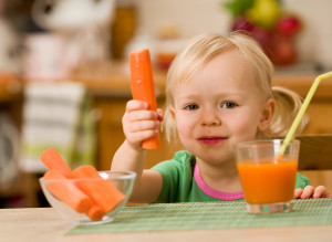 Маленькая девочка с морковью и морковным соком