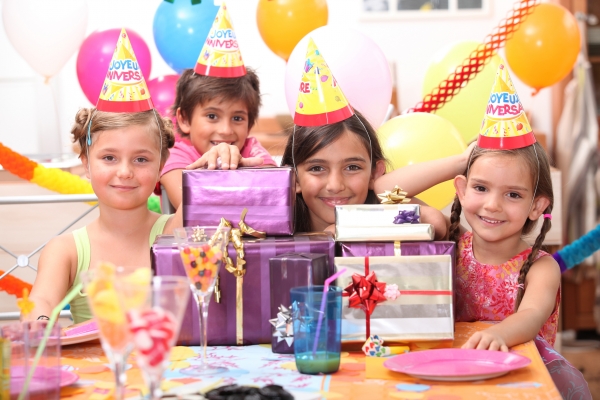 Дети в разноцветных колпаках празднуют день рождение