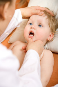 Стоматолог осматривает уздечку у ребенка