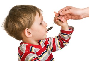 Мальчик принимает лекарство - фото