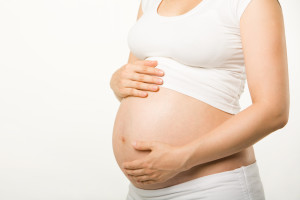 Беременная женщина в белом бюстгалтере-топе