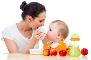 Мама кормит маленького ребенка - фото