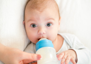 Малыш ест смесь из бутылочки  - фото