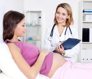 Беременная женщина на приеме у врача - фото
