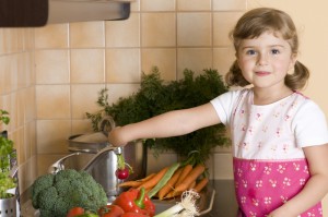 Маленькая девочка помогает на кухне - фото