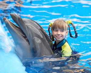 Девочка плавает вместе с дельфином