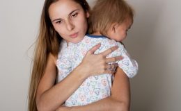 Расстроенная женщина обнимает ребенка