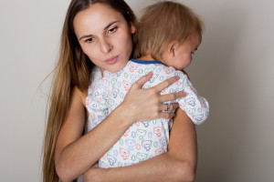 Расстроенная женщина обнимает ребенка