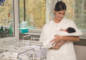 Мама держит на руках новорожденного - фото