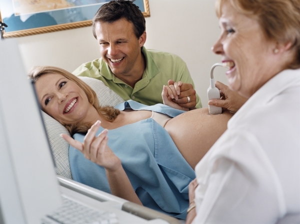 Доктор проводит осмотр беременной на аппарате УЗИ - фото