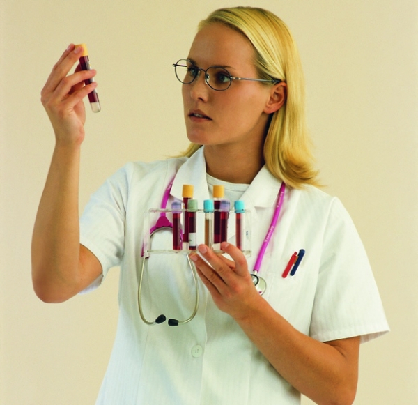 Медсестра держит пробирки с кровью - фото