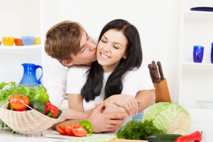 Молодая пара готовят обед из овощей - фото