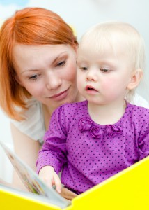 Мама читает книгу маленькой девочке - фото