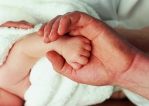 Рука ребенка в руках отца - фото