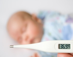Младенец и градусник с повышенной температурой