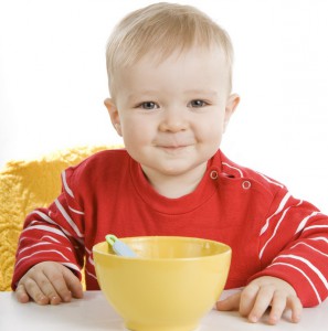 Маленький мальчик ест кашу - фото