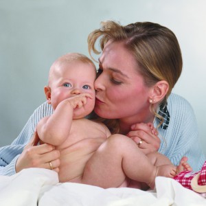 Мама целует младенца