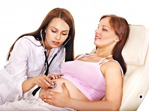 Доктор прослушивает живот беременной (фото Burda Media)