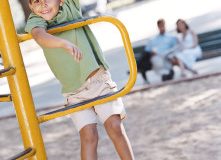 Мальчик гуляет на детской площадке - фото