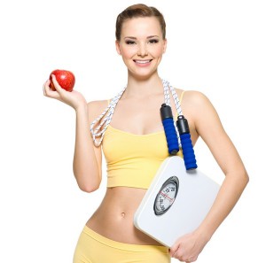 Стройная женщина с весами и с яблоком в руках - фото