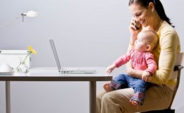 Мама с младенцем смотрят в ноутбук - фото