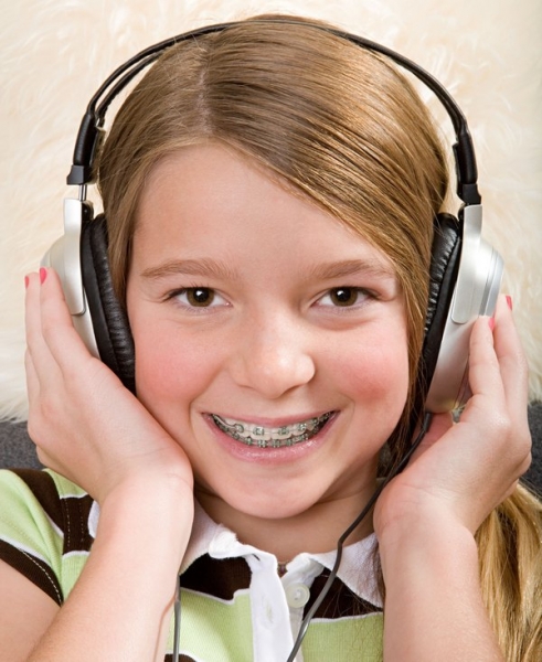 Девочка в наушниках слушает музыку - фото