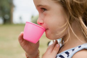Девочка пьет с чашки - фото