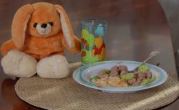 Еда на тарелочке для ребенка и мягкая игрушка рядом с тарелкой - фото