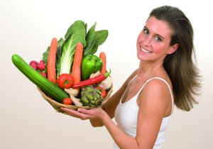 Женщина держит корзину с овощами - фото