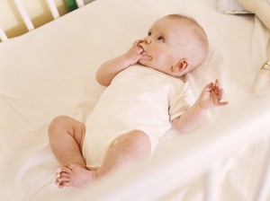 Младенец лежит в кроватке - фото
