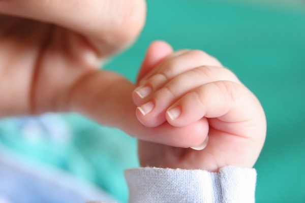 Младенец держит маму за палец - фото