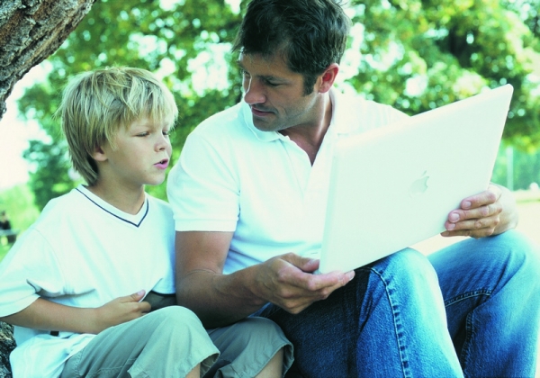Сын с отцом смотрят в ноутбук - фото