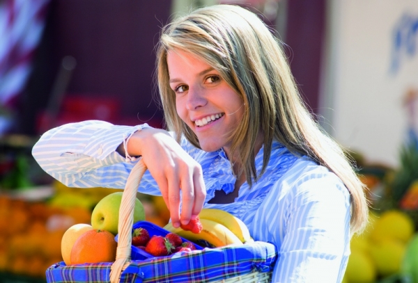 Женщина держит корзину с фруктами - фото