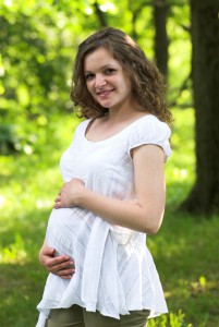 Беременная женщина гуляет в парке 