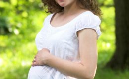 Беременная женщина гуляет в парке