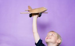 Мальчик играет с самолетом - фото