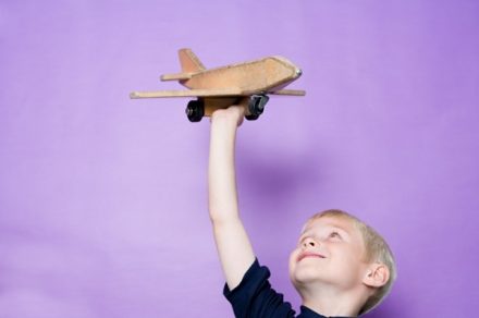 Мальчик играет с самолетом - фото