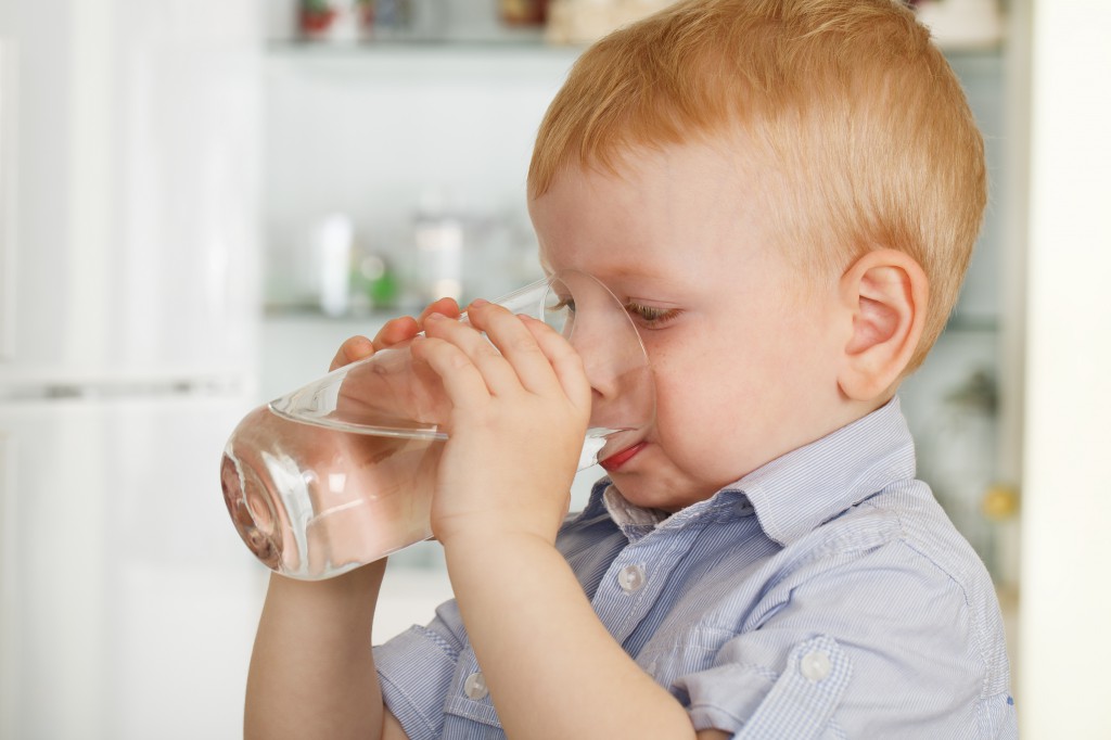 Мальчик пьет воду из стакана - фото